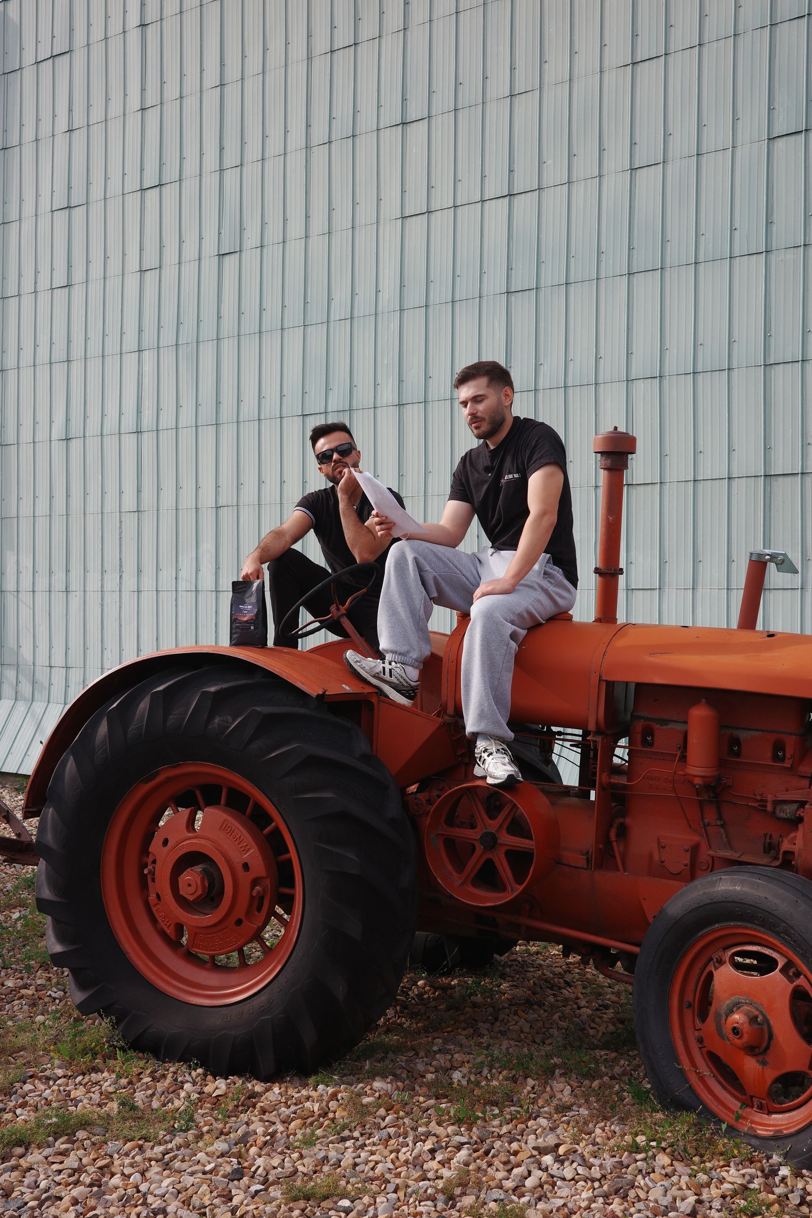 Two people sitting on a vintage orange tractor