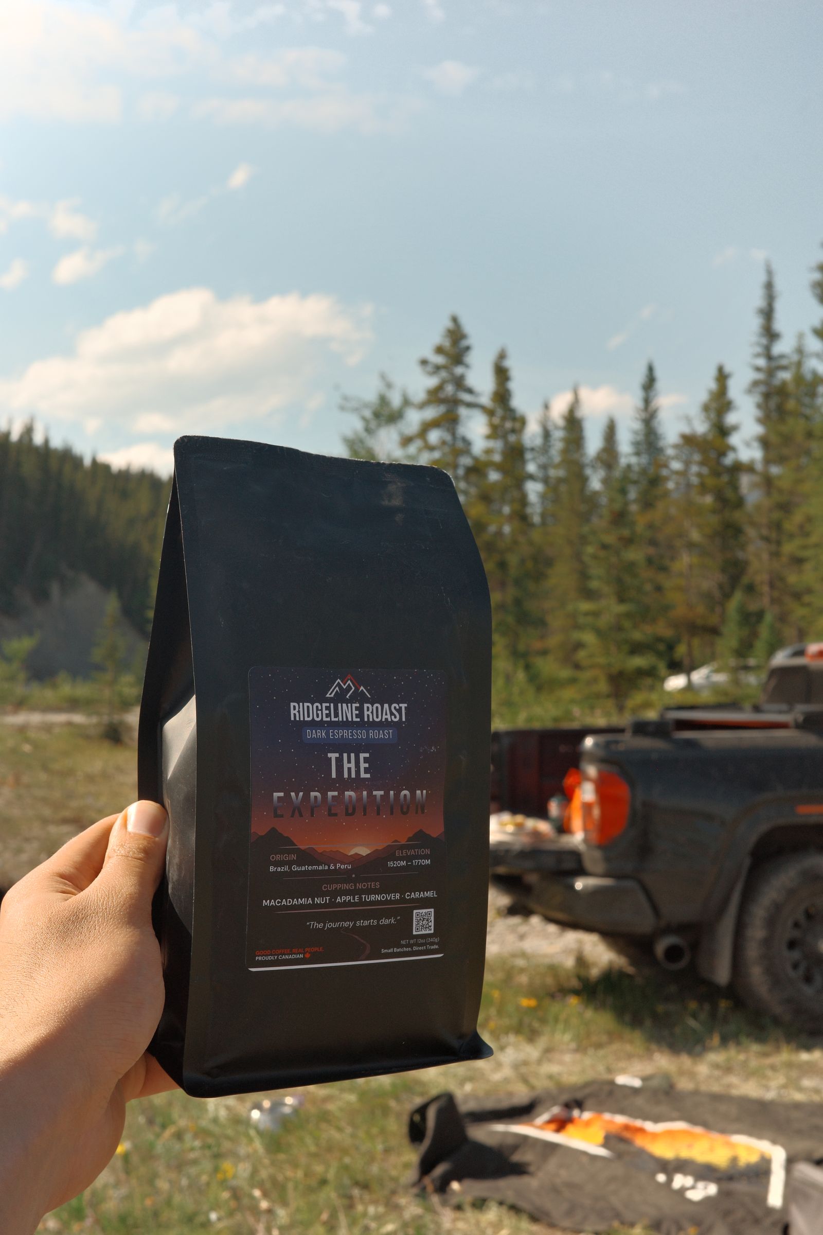 A bag of The Expedition held up in the pines, with the truck behind
