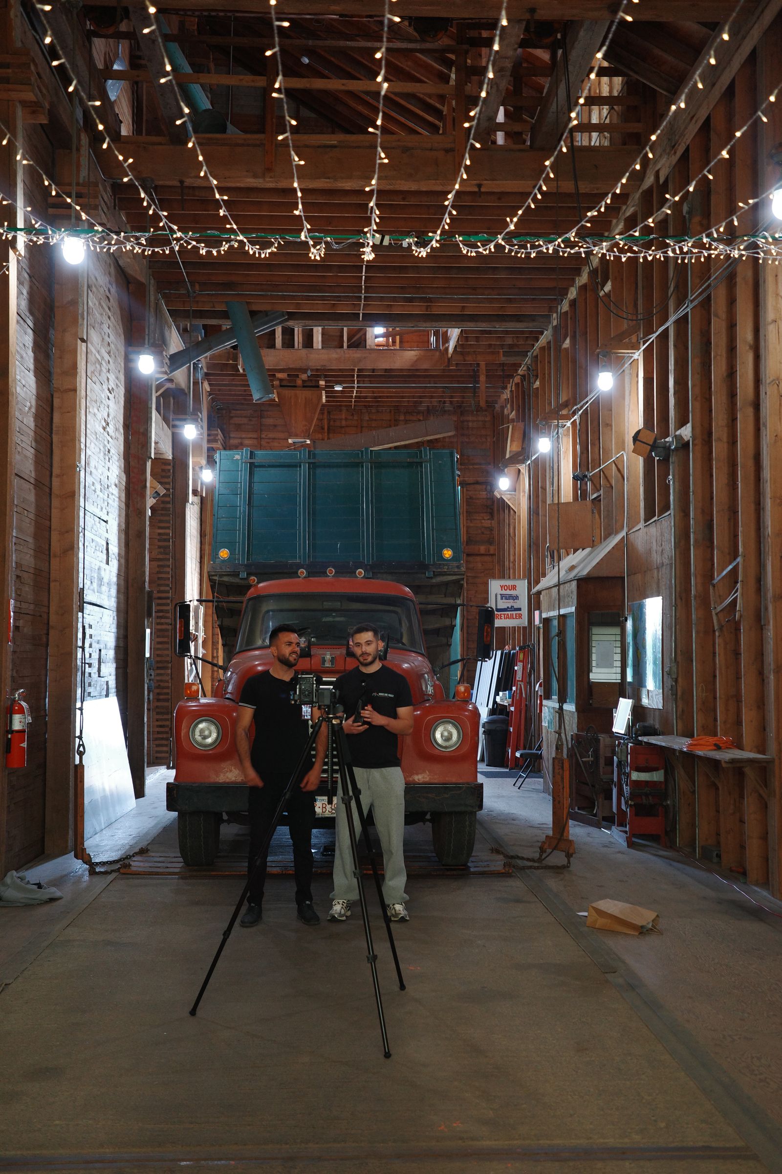 Filming inside a wooden barn in front of a vintage red truck