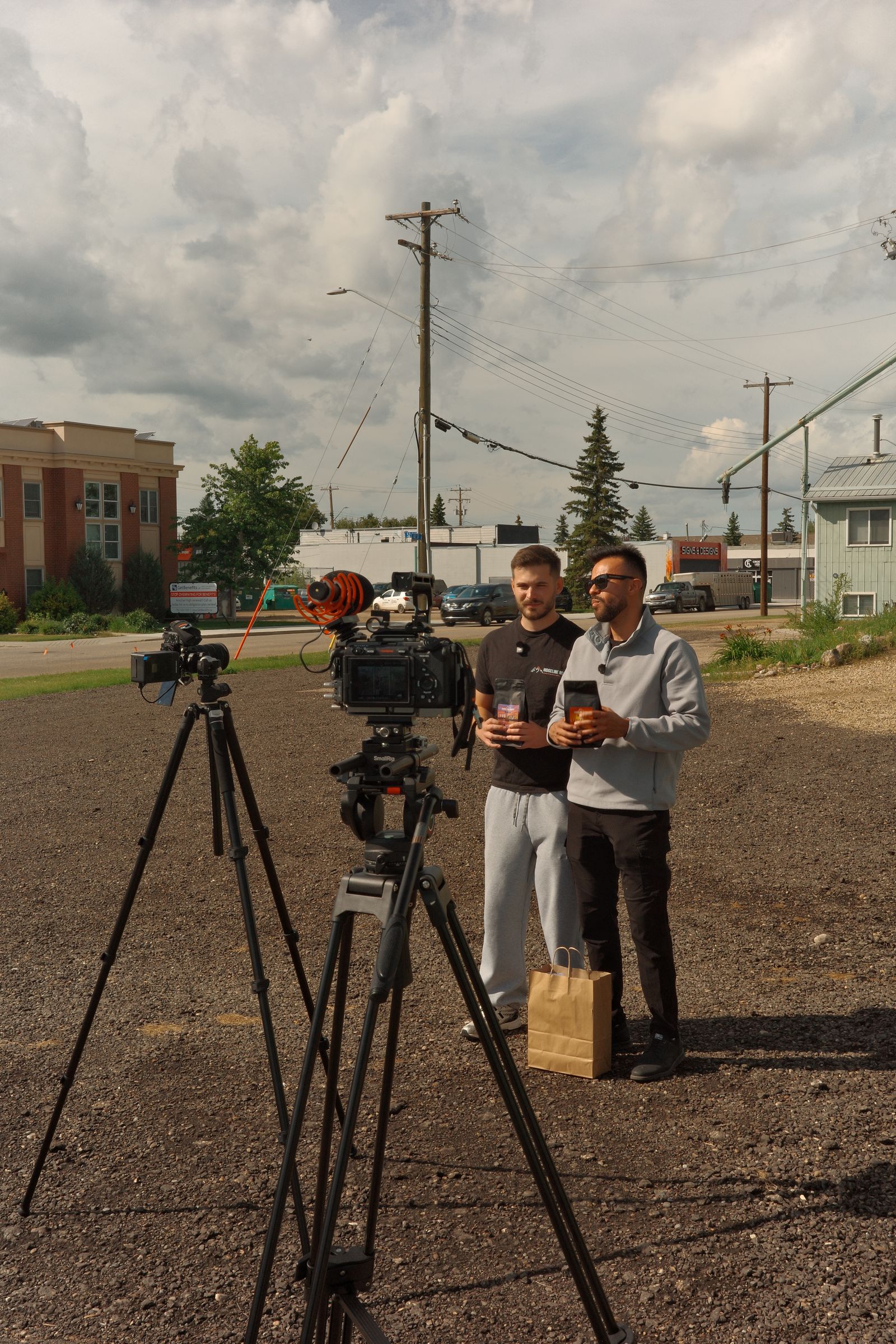Cameras on tripods set up on a gravel lot in town