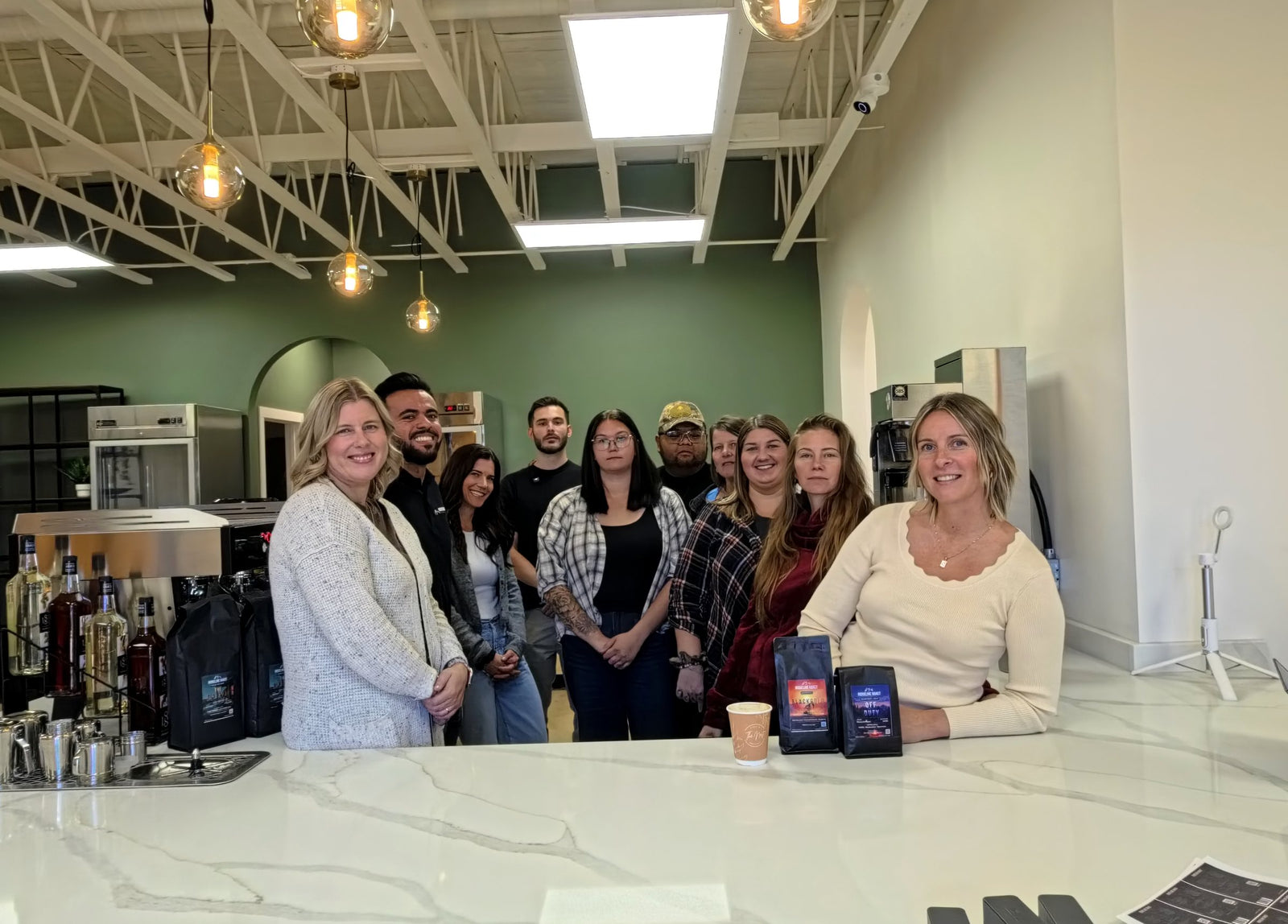 The Nest Cafe team in Cold Lake with the Ridgeline crew behind the counter, Ridgeline bags on the counter